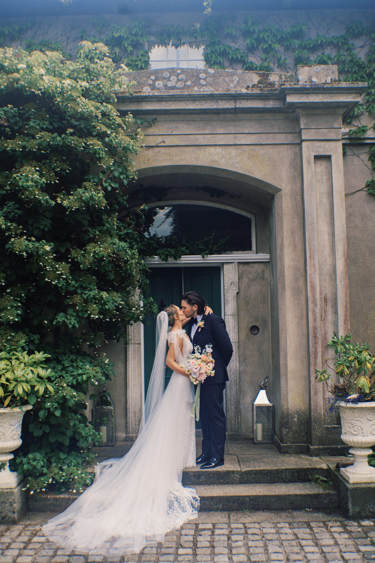 a man and woman kissing in front of a building